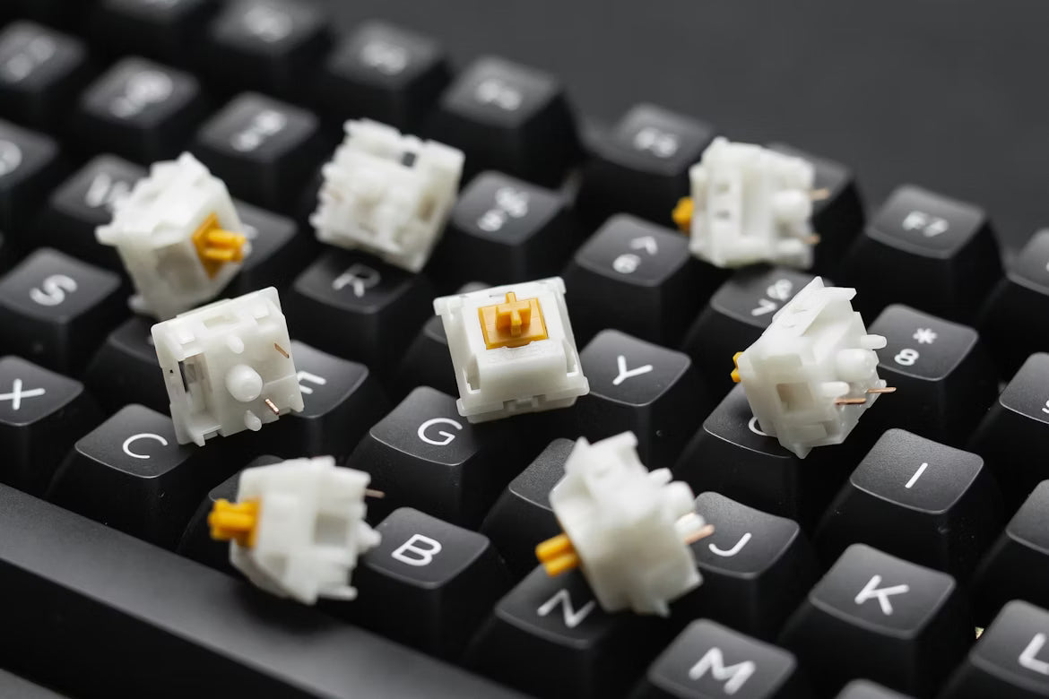 Mechanical keyboard switches with orange stems on black keycaps for custom setups